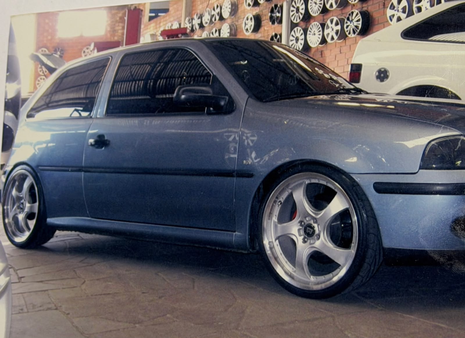 VW Gol branco em frente à oficina